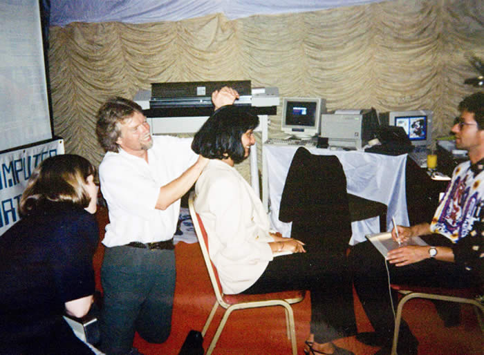 Virgin Atlantic Airlines CEO and Founder, Sir Richard Branson, massages my portrait subject while I performed at the Virgin Atlantic Tenth Anniversary Party in London, UK, 1994.